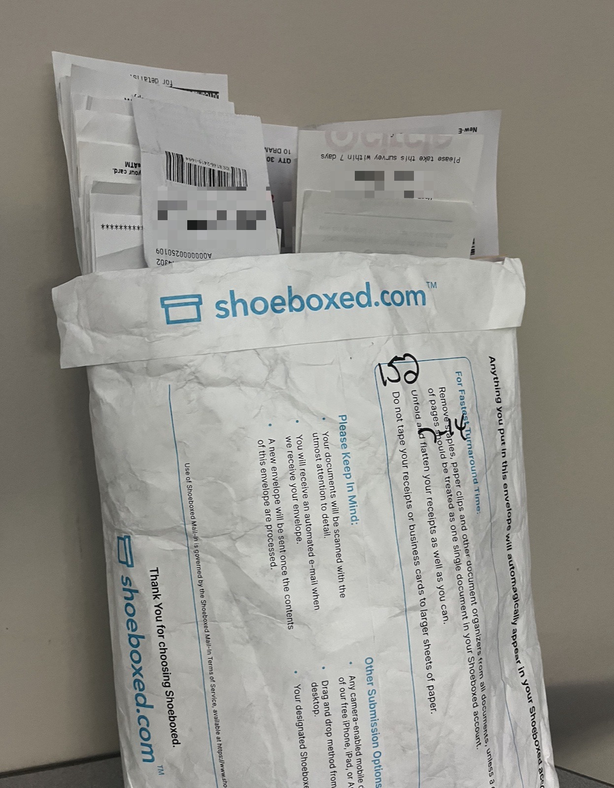 A Shoeboxed Magic Envelope full of customer receipts with a handwritten count of 152 on the front, ready to be processed
